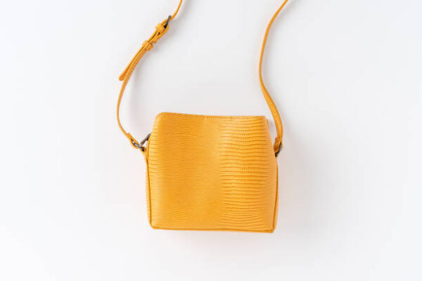 Yellow woman’s purse isolated on white background. top view
