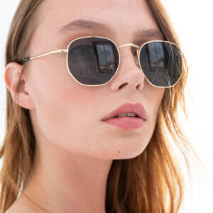 Blonde freckled girl wearing sunglasses. photo studio with sunlight.