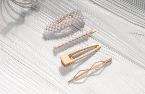 Golden with pearls hairpin clip set on white wooden background