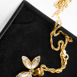 Beautiful gold necklace with pearls and crystals pendant in jewel box closeup